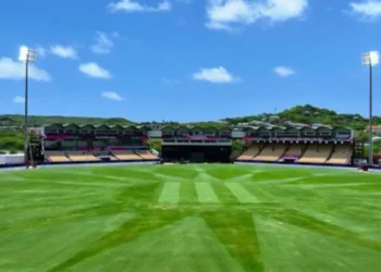 A 2018 vibrant view of the Daren Sammy Cricket Ground in Saint Lucia under clear blue skies, showcasing the stadium's lush green outfield and iconic stands.