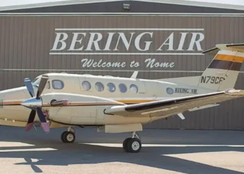 A Bering Air Cessna 208B Grand Caravan parked in front of a hangar with Welcome to Nome signage. The aircraft is similar to the missing Alaska plane carrying 10 people.
