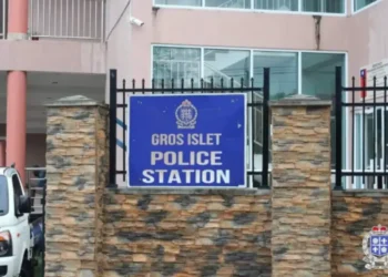 Gros Islet Police Station entrance with a blue sign and security fencing. St Lucia Police investigate missing M16 rifle from this facility.