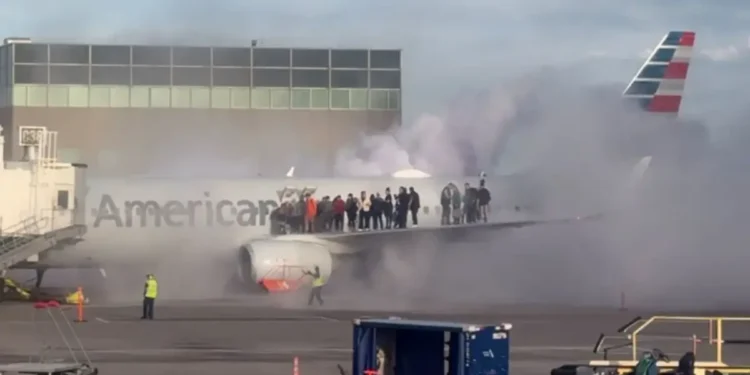 Passengers evacuate onto the wing as an American Airlines plane catches fire at Denver International Airport, with thick smoke filling the air.