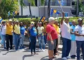 Barbadians protest land sales during a peaceful Holetown march on March 22, 2025, waving national flags in opposition to state land deals.