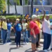 Barbadians protest land sales during a peaceful Holetown march on March 22, 2025, waving national flags in opposition to state land deals.