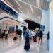 Passengers walking through a newly renovated concourse at Charlotte Douglas Airport near the TSA checkpoint.