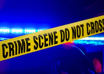 Crime scene with police tape after man killed in Choiseul concrete block attack, with emergency lights flashing in the background.