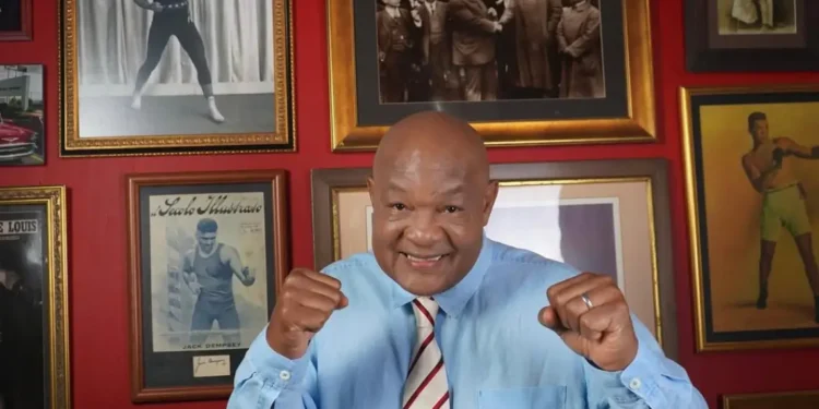 George Foreman dies at 76: boxing legend smiles in tribute photo wearing blue shirt, surrounded by historic fight memorabilia
