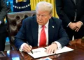 U.S. President Donald Trump signing an executive order in the Oval Office as his new travel ban targets 43 countries, imposing strict immigration restrictions.
