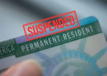 U.S. green card with ‘SUSPENDED’ stamp as US suspends green card processing.