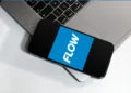 Smartphone displaying Flow logo next to laptop, referencing Flow St Lucia internet price increase.