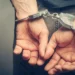 Hands of arrested man in handcuffs after Port Castries drug and gun bust