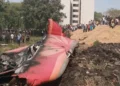 Air India Flight 171 crash wreckage with tail debris and crowd in Ahmedabad