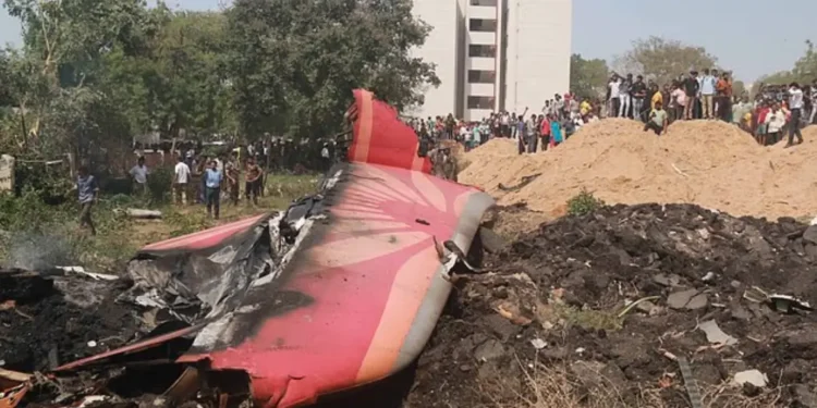 Air India Flight 171 crash wreckage with tail debris and crowd in Ahmedabad