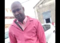 Qwami shot dead in Marchand, seen wearing a pink jacket outside a church.