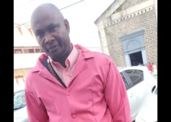 Qwami shot dead in Marchand, seen wearing a pink jacket outside a church.