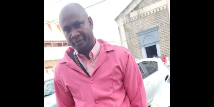 Qwami shot dead in Marchand, seen wearing a pink jacket outside a church.
