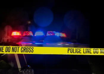 Stock image of police car with flashing lights and crime scene tape used to illustrate RSLPF Castries Operation amid gun violence crackdown.