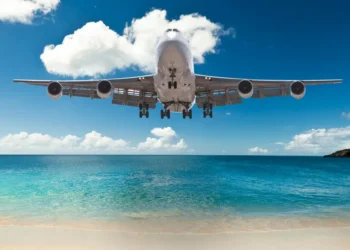 Commercial airplane flying low over Caribbean waters, symbolizing improved Caribbean air connectivity through CTO–ASM partnership