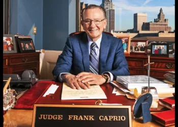 Judge Frank Caprio dies at 88, former Providence Municipal Court chief smiling at his office desk with nameplate and family photos.