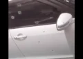 Bullet-riddled white car targeted in Marchand daylight gun attack, showing multiple bullet holes on the door and window