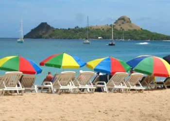 Tourists relax under colorful umbrellas at Reduit Beach before access was restricted by the St Lucia government