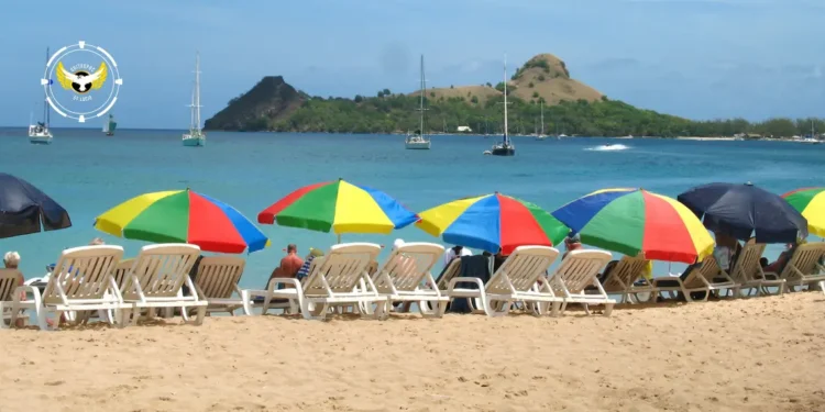 Tourists relax under colorful umbrellas at Reduit Beach before access was restricted by the St Lucia government