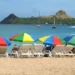 Tourists relax under colorful umbrellas at Reduit Beach before access was restricted by the St Lucia government