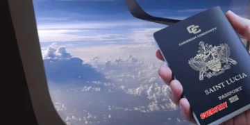 Hand holding a Saint Lucia passport by airplane window, symbolizing St Lucia US visa overstay rate issue.