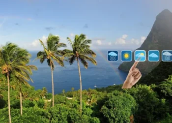 View of St Lucia Pitons with palm trees, rainbow, and weather forecast icons illustrating St Lucia weather August 23 2025.