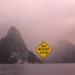 Graphic illustration of the Pitons in St Lucia under stormy skies with a sign reading Bad Weather Ahead for the St Lucia weather August 24 2025 update.