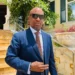 Stephen Fevrier, wearing a blue suit and sunglasses, stands outside a building in Castries after delivering his Stephen Fevrier crime statement on August 19, 2025