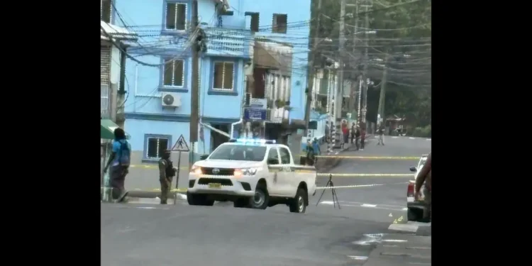 Police vehicle and officers secure the crime scene in Wiltons Yard fatal shooting that left 1 dead and 1 injured in St Lucia.