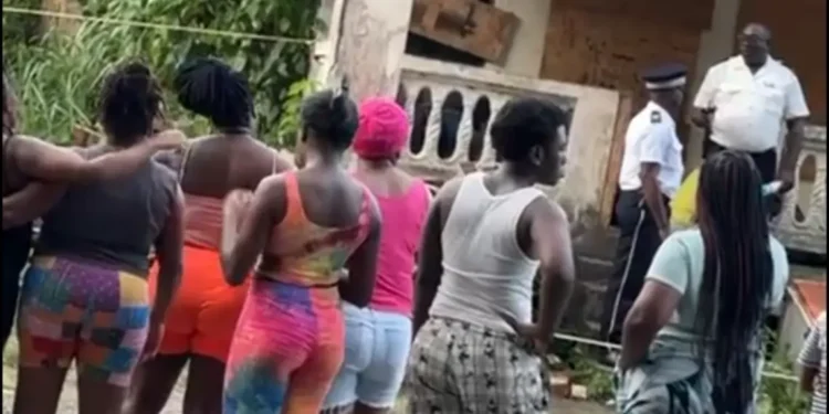 Police speak with residents gathered outside an abandoned house in Bexon after two men shot in Bexon, leaving one dead and one critically injured.