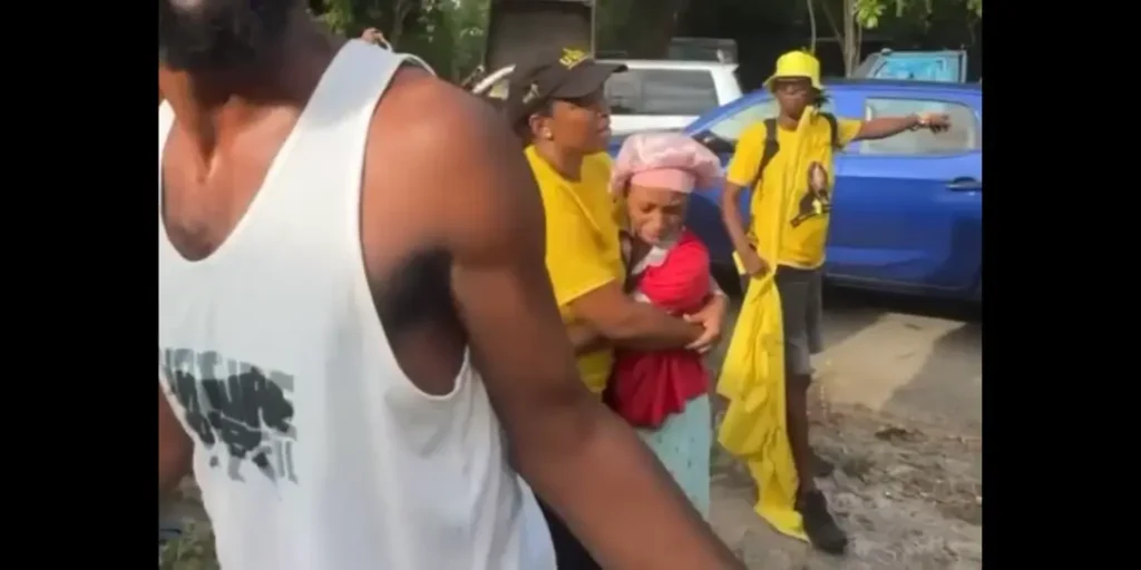 Marcella Johnson comforting a frightened child after the Gros Islet house fire during campaign motorcade