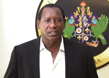 UWP PRO Lenard Montoute speaks in front of the opposition crest and Saint Lucia flag as UWP accuses SLP of hypocrisy on crime, policing and free speech