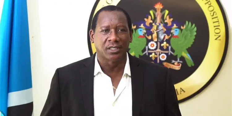 UWP PRO Lenard Montoute speaks in front of the opposition crest and Saint Lucia flag as UWP accuses SLP of hypocrisy on crime, policing and free speech