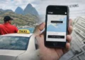 A licensed taxi driver in St Lucia beside his vehicle while a smartphone displays the Uber app during Uber registration in St Lucia.