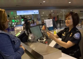 US visa bond requirement as a CBP officer reviews a traveler’s documents at an airport inspection counter