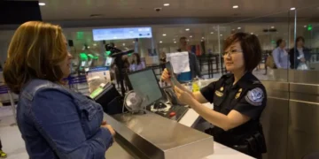 US visa bond requirement as a CBP officer reviews a traveler’s documents at an airport inspection counter
