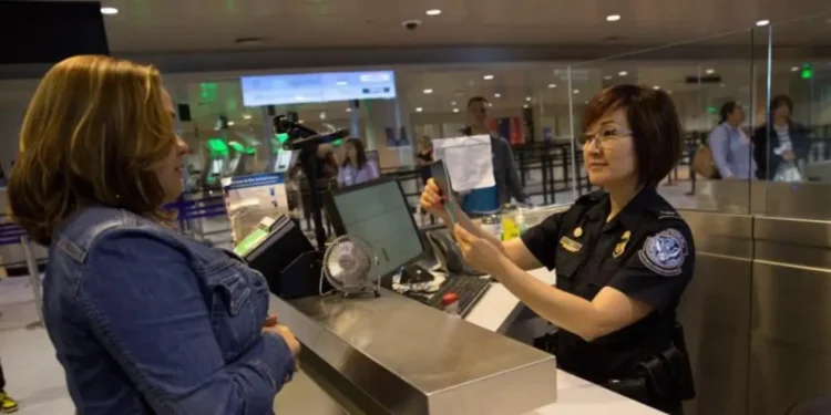 US visa bond requirement as a CBP officer reviews a traveler’s documents at an airport inspection counter