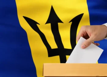 Thorne urges Mottley to delay Feb 11 general election as a ballot is placed into a box against the Barbados flag