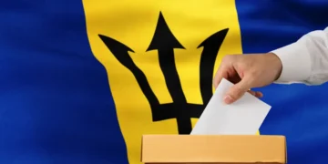 Thorne urges Mottley to delay Feb 11 general election as a ballot is placed into a box against the Barbados flag