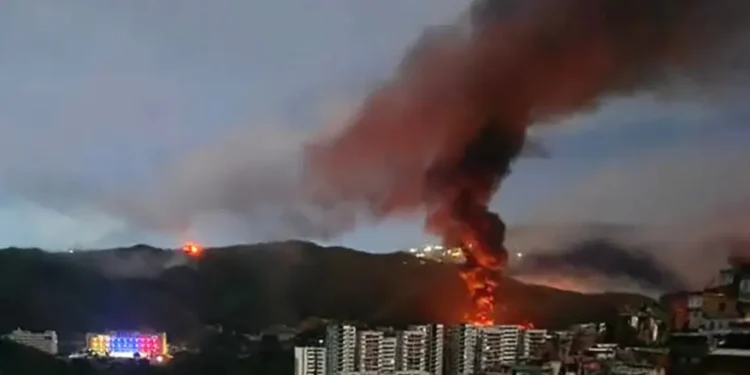 Fire and smoke rise over Caracas following reports linked to the US strike in Venezuela.
