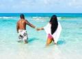 Blue Lagoon Island Adults-Only Beach concept, couple wading in turquoise water near Nassau