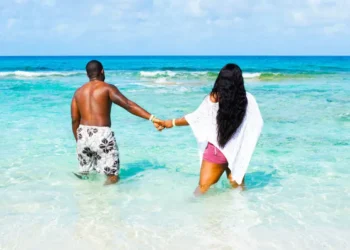 Blue Lagoon Island Adults-Only Beach concept, couple wading in turquoise water near Nassau