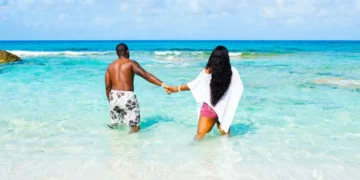Blue Lagoon Island Adults-Only Beach concept, couple wading in turquoise water near Nassau