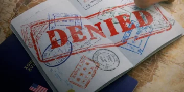 U.S. reiterates forced labor warning as a passport stamped “denied” illustrates official enforcement action