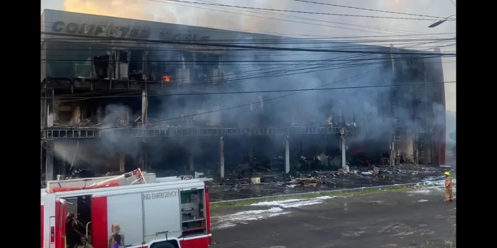 Aftermath of the Computer World fire shows extensive damage to the Bois d’Orange commercial building in daylight