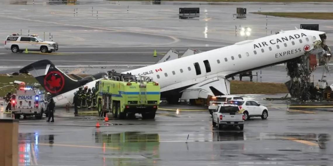 LaGuardia crash scene showing damaged Air Canada Express plane on runway with emergency crews
