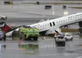 LaGuardia crash scene showing damaged Air Canada Express plane on runway with emergency crews