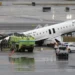 LaGuardia crash scene showing damaged Air Canada Express plane on runway with emergency crews
