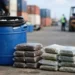 Illustrative image of Vieux Fort hashish seizure showing a blue barrel and vacuum-sealed drug packages at a seaport